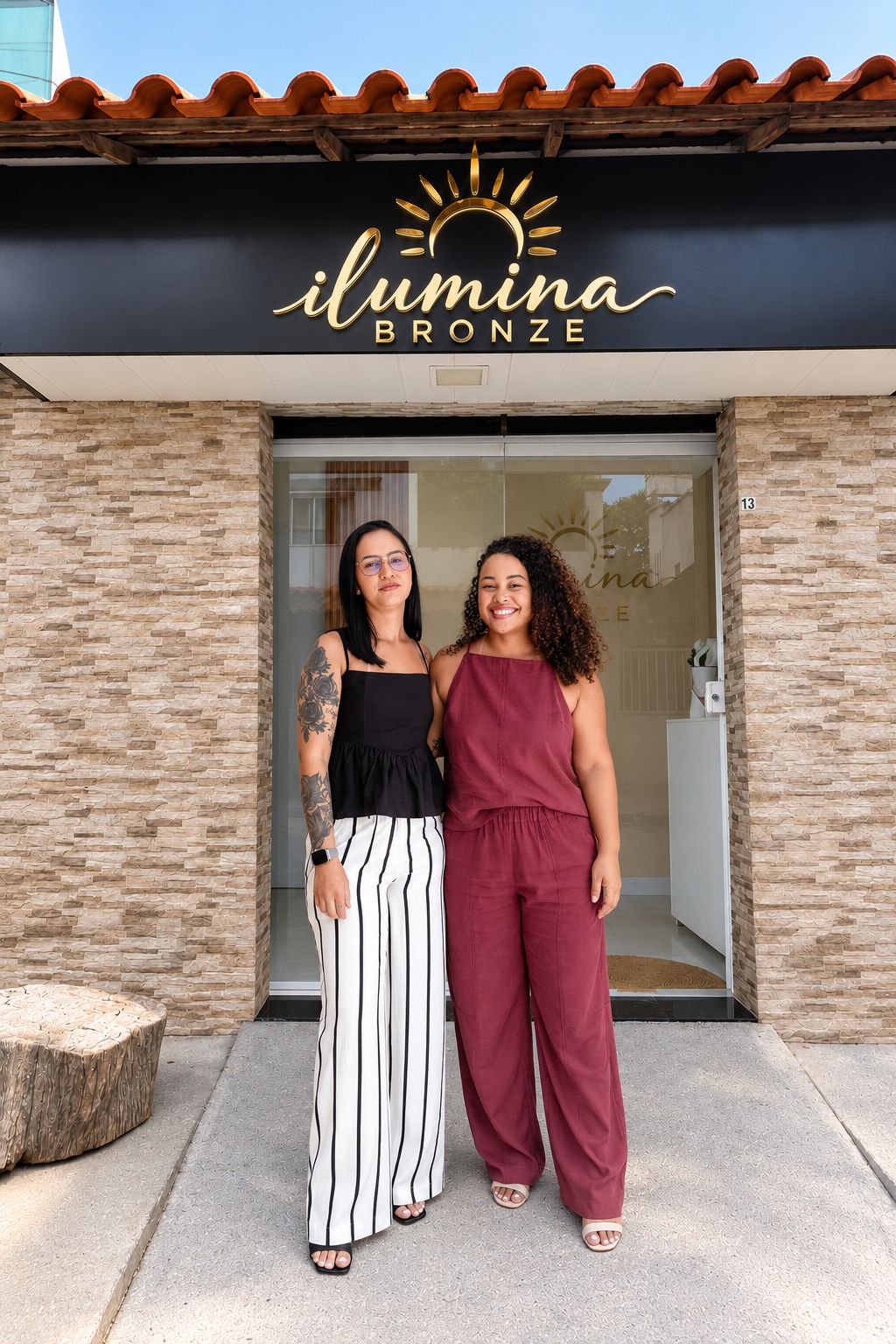 Equipe da Ilumina Bronze em frente à fachada do espaço, sob o letreiro dourado